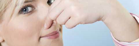 woman holding her nose because of the nasty odor coming from the drain